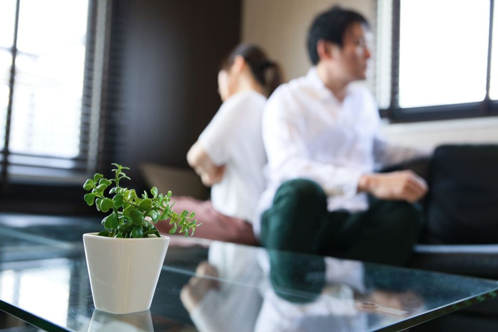 背中を向け合ってソファーに座る男女