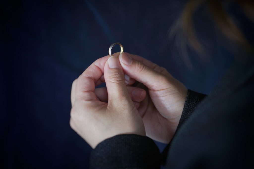 指輪を両手で持つ女性の手