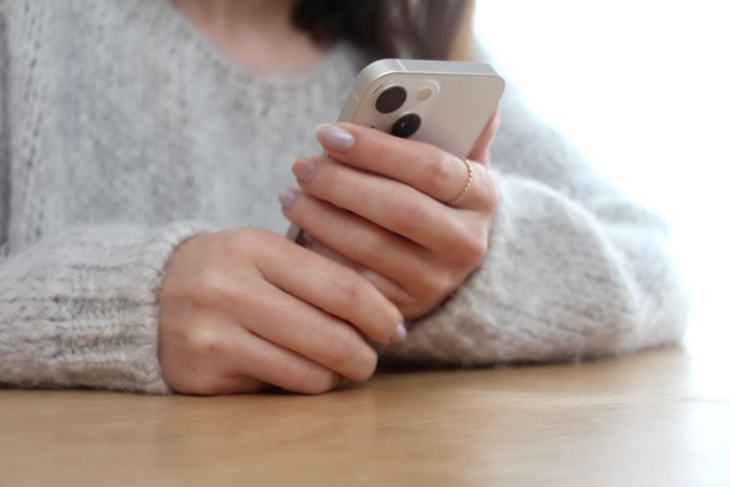 スマートフォンを持つ女性の手