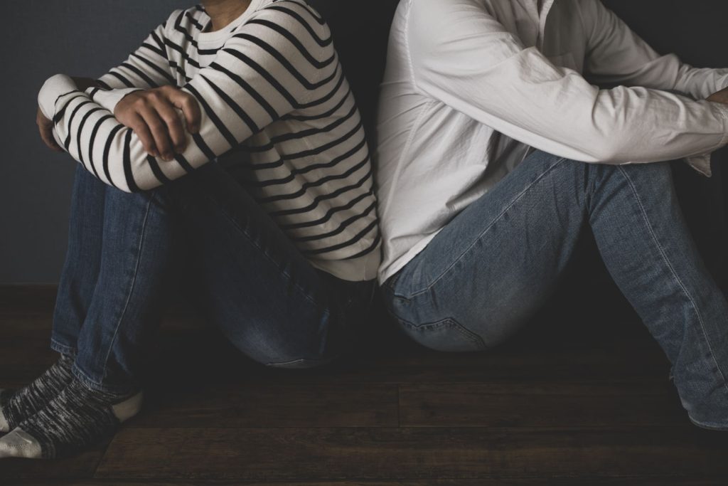 背中を向け合って座る男女