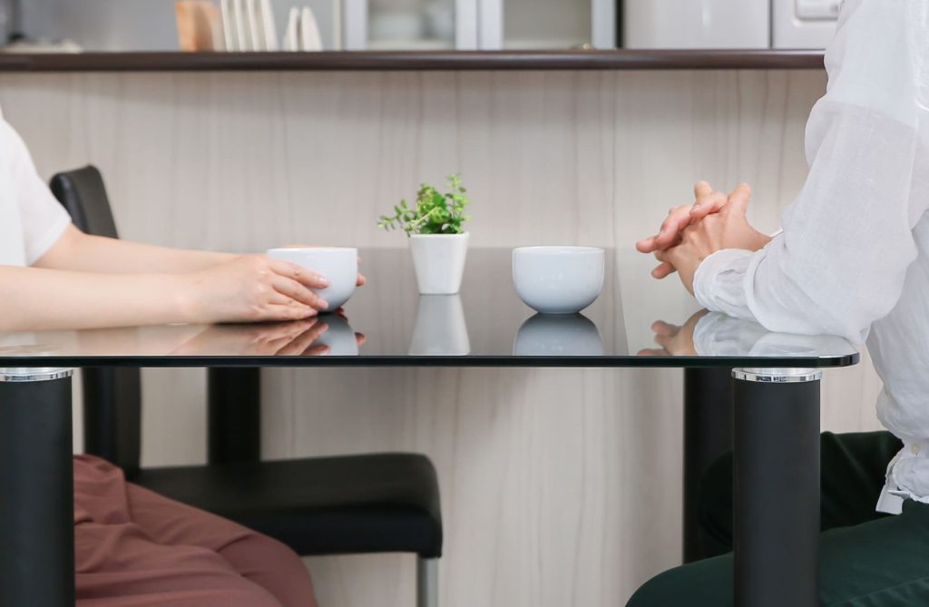 テーブルを挟んで向き合う男女